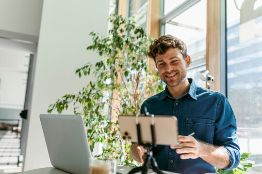 Confident young businessman discussing on video call in cafe