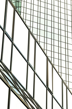 Modern corporate office building in skyscraper architecture with glass facade windows and linear reflection on exterior structure for business design