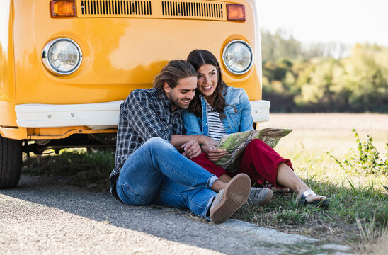 Couple on a road trip in their camper, looking at map