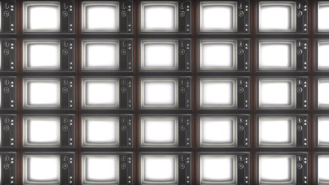 Grid of vintage television screens glows sequentially in soft white light over dark background as camera zooms out to show complete wall layout
