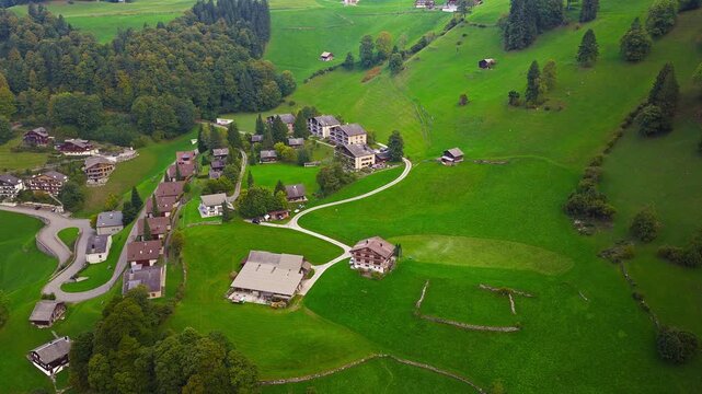 Cinematic drone shot of alpine Swiss village with mountains, 4K