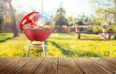 summer time in backyard garden with grill BBQ, wooden table, blurred background