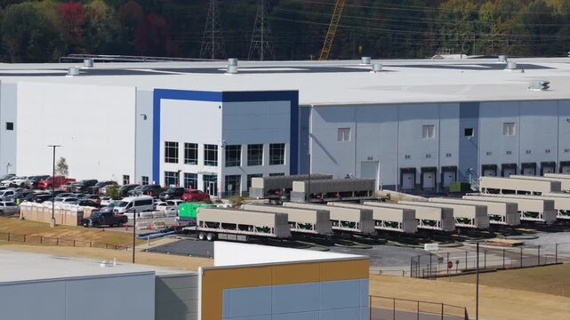 Tight aerial shot sliding right past mobile generator units staged outside a large data facility