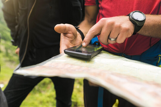 Two hikers searching for the right path with map and GPS, Carpathian Mountains, Romania