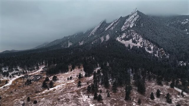 Flat Irons Mountain Winter Chautauqua Park aerial drone Colorado USA snowing snow flakes snowfall dusk sunset low clouds grass snow covered Rock formation walking loop trail Bear Peak forward upward
