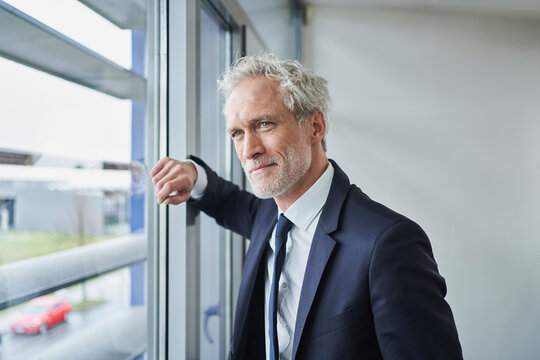Portrait of confident businessman looking out of window