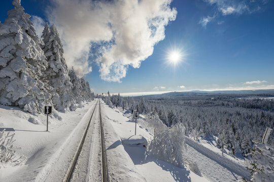 Germany, Saxony-Anhalt, Harz National Park, Brocken, rail tracks of Harz Narrow Gauge Railway in winter against the sun