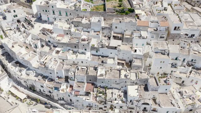 Aerial view of closely packed white buildings creating a stunning contrast against the clear sky, Ostuni, Apulia, Italy.