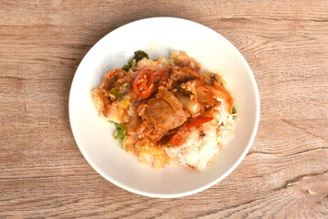 grilled slice pork with onion and chili topping steamed creamy egg dressing Korean sauce on rice in plate