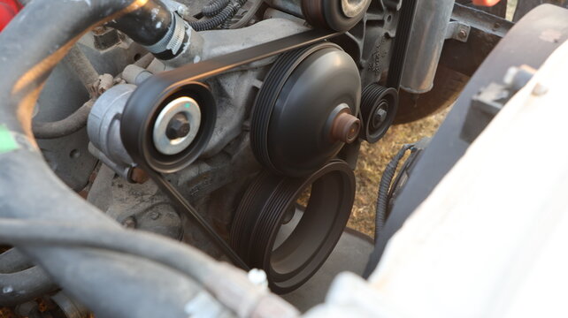 Close up of car engine accessory serpentine belt and pulleys