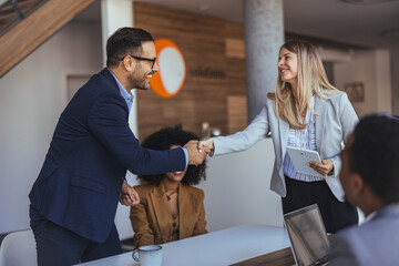 Professional Man And Woman Shake Hands In Modern Office During Meeting And Collaboration