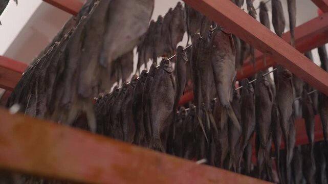 Dried salted fish hanging on racks in a fish market