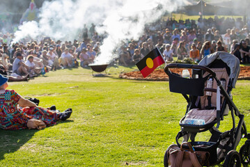 Australian aboriginal flag attached to baby stroller at indigenous community ritual smoking ceremony rite © Elena Pochesneva