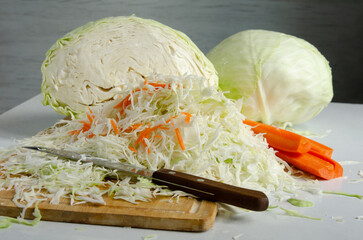 Fresh white cabbage and carrots sliced ​​on table for salad or cooking