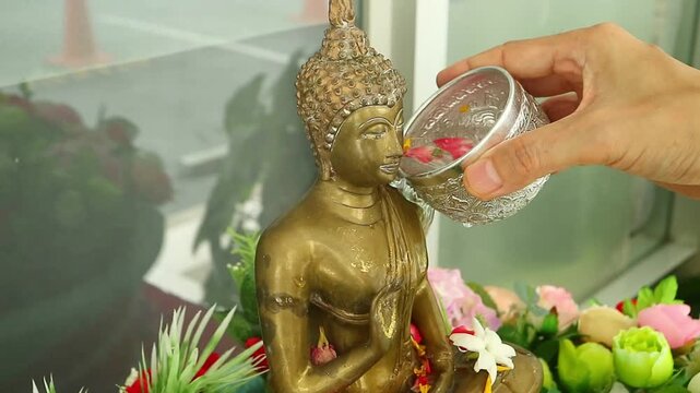 Footage of people pouring scented water on Buddha image to pay respect on Songkran festival or Thai new year