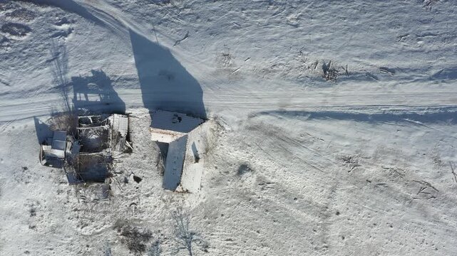 Aerial view of snow-covered houses and roads creating a stark contrast with the dark tree shadows, Holbav, Brasov, Romania.