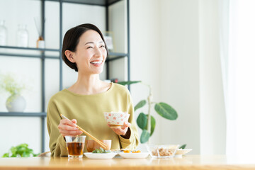 家で朝ごはんを食べるミドルの女性