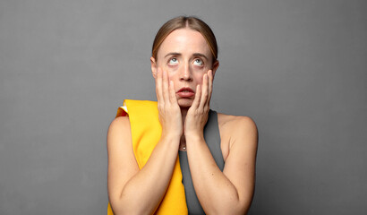feeling shocked and scared, looking bored with hands on cheeks. fitness concept