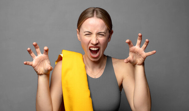 screaming in panic or anger, shocked, terrified or furious, with hands next to head. fitness concept