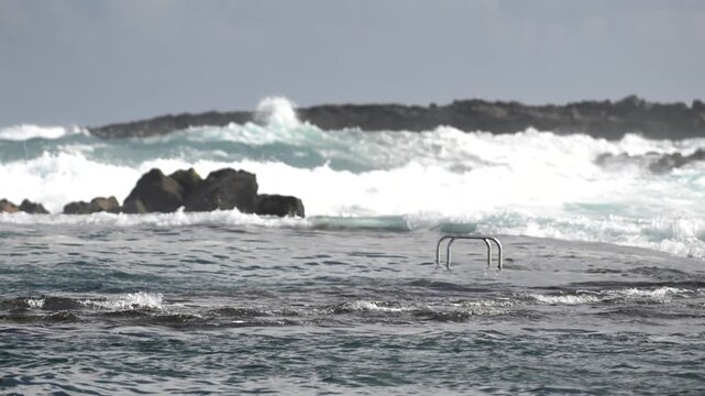 Cinematic aerial of massive Atlantic waves crashing on Gran Canaria coast with dangerous swell and red flag sea conditions