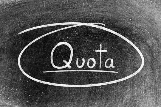 White chalk hand writing in word quota and circle shape on blackboard background