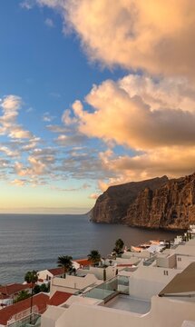 Golden sunset bathes Tenerife's rugged cliffs, whispering tales of Atlantic serenity, perfect for Dia de Canarias celebrations