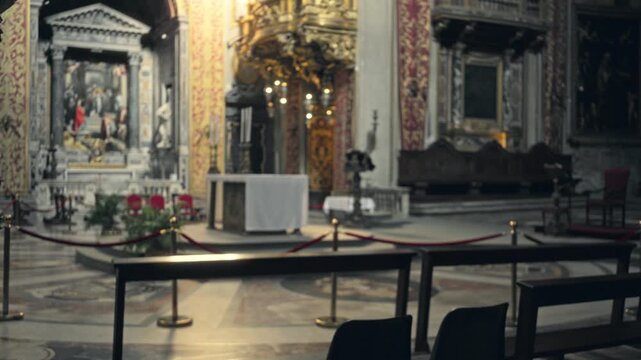Blurred catholic church interior with soft bokeh and defocused altar, seating rails and ornate wall details; backplate copyspace background calm.