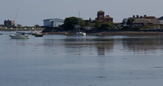 wide panning shot Roa Island, RNLI Barrow lifeboat stationand Lile Island and castle at low tide from Roa Island Road.