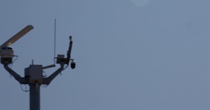 Wide panning shot right to left of the radar on the coastal monitoring system mast at the Trafalgar Point, stone jetty in Morecambe
