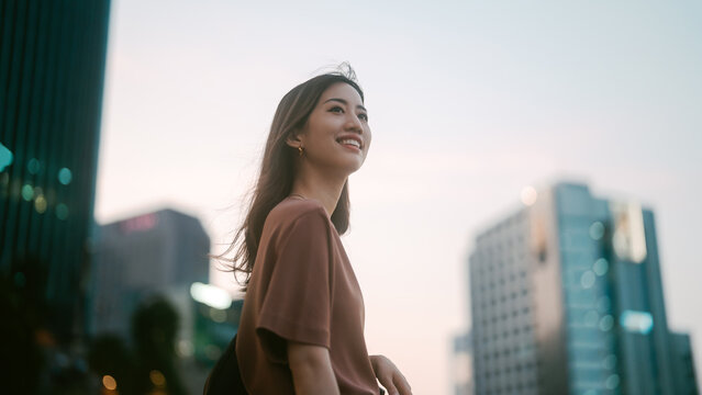 Positive beautiful smiling portrait single business asian woman standing at outdoors city building background