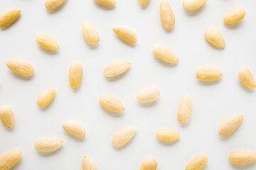 Almond nuts on light gray table background. Closeup. Food pattern. Top down view.