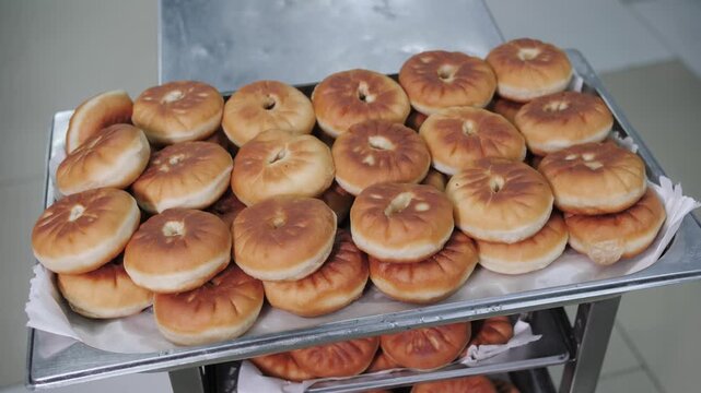 A large number of delicious pies on a tray in the production hall. Belyashi
