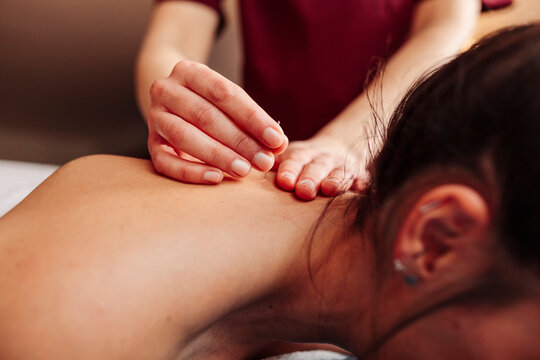 Physiotherapist inserting needle on back while applying dry needling therapy