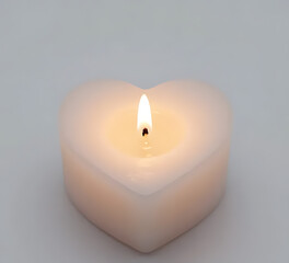 Heart-shaped candle with soft romantic glow, clean background, valentine object