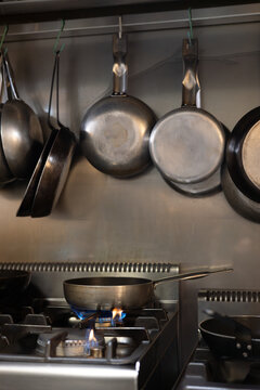 Cooking pan warming on gas stove in stainless steel kitchen