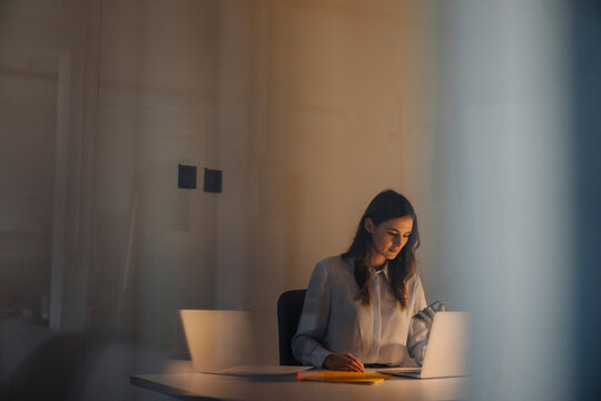 Young businesswoman working late at desk in office