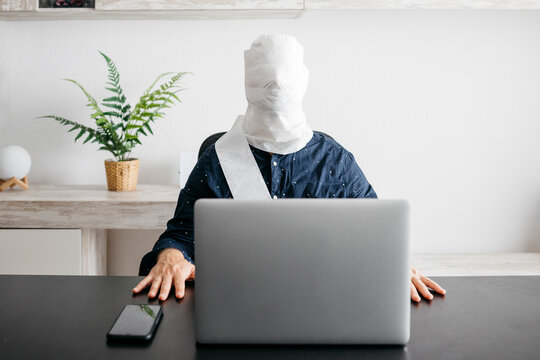 Man working at home with his head covered in toilet paper