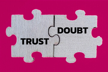 Fototapeta premium Conceptual Jigsaw Puzzle Pieces with Trust and Doubt Text on Pink Background - Business Strategy, Relationship, and Emotion Concept
