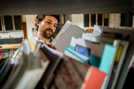 Businessman reading file at shelf in office