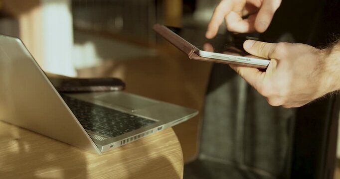 Professional stock footage showing hands holding a tablet next to an open laptop, symbolizing IT support, technical assistance, troubleshooting, and modern digital problem solving in an office or home