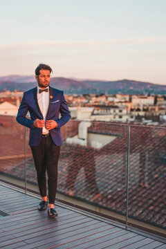 Italy, Florence, Portrait of stylish man on roof terrace at sunset