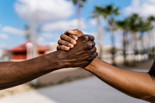 Young men shaking hands on outdoor basketball court