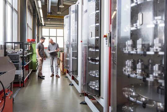 Two men examining product in modern factory