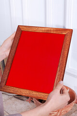 In the decorative background, a woman is holding a picture frame.