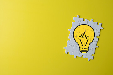 Creative idea and innovation concept with copy space. White jigsaw puzzle with yellow light bulb. Symbol of smart thinking, solution, business strategy, and imagination.,copyspace.