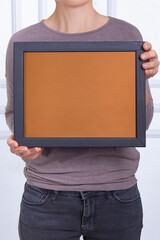 In the decorative background, a woman is holding a picture frame.
