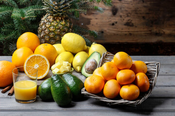 Glass of juice and various fruits on wooden table.