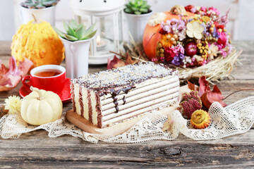 Delicious sponge cake, layered with coconut cream among various autumn decorations.