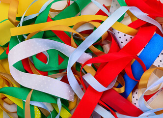 Top view of messy pile of colorful satin ribbons for handicraft and gift wrapping