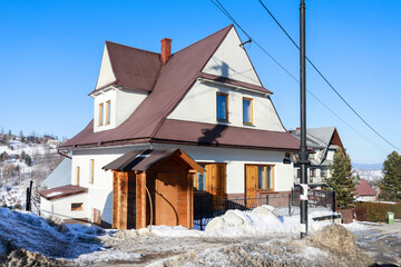 BUKOWINA TATRZANSKA, POLAND - JANUARY 19, 2025: 
A brick highlander house and a booth selling local products right in front of it.